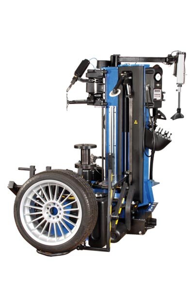 Das Bild zeigt eine moderne Reifenmontiermaschine in Blau und Schwarz mit montiertem Reifen, verschiedenen Hebearmen, Werkzeughalterung und Steuerbedienelementen.