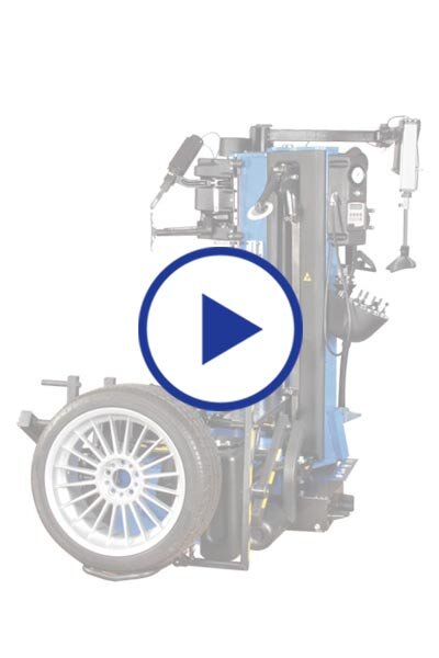 Das Bild zeigt eine Reifenmontiermaschine in Blau und Schwarz mit montiertem Rad, überlagert von einem großen Play-Symbol, das auf ein Video oder eine Animation hinweist.