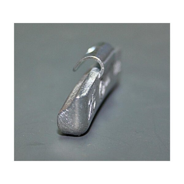 Das Bild zeigt eine geöffnete Pappschachtel, gefüllt mit vielen kleinen, silberfarbenen Metallgewichten. Vor der Schachtel liegen neun einzelne Gewichte unterschiedlicher Größe und Form, die in zwei Reihen angeordnet sind. Die Gewichte sind gebogen und haben auf jeder Oberseite eine kleine Metallklammer. Jedes Gewicht ist mit einer Zahl und zusätzlichen technischen Angaben beschriftet, die vermutlich das Gewicht oder die Maße angeben. Die gesamte Szene befindet sich auf einer grauen Fläche.