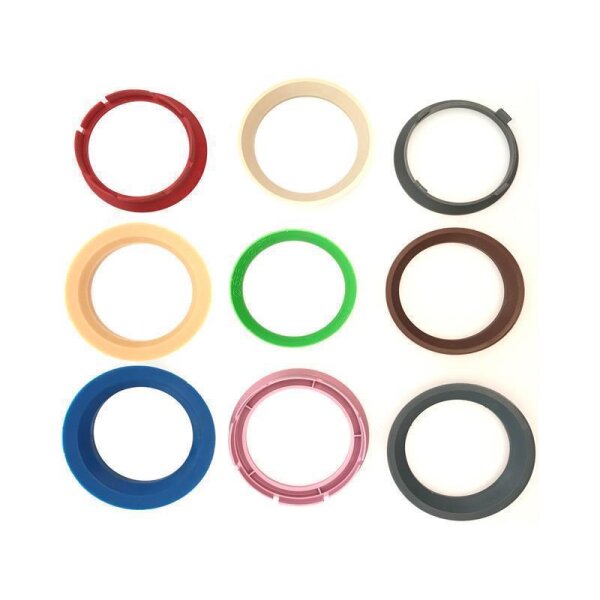 Das Bild zeigt neun unterschiedlichfarbige Kunststoffringe, angeordnet in einem 3x3-Raster auf weißem Hintergrund. Obere Reihe von links nach rechts: ein roter Ring, ein cremefarbener Ring, ein dunkler grauer Ring. Mittlere Reihe von links nach rechts: ein gelblich-beiger Ring, ein grüner Ring, ein brauner Ring. Untere Reihe von links nach rechts: ein blauer Ring, ein rosa Ring, ein weiterer grauer Ring, der dunkler als der obere graue Ring ist. Alle Ringe sind rund und haben einen glatten Rand, einige besitzen kleine erhabene Details oder Einkerbungen.