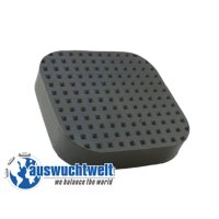 Das Bild zeigt einen schwarzen, quadratisch geformten Gummipuffer mit abgerundeten Ecken. Die Oberseite des Puffers ist mit vielen kleinen, quadratischen Vertiefungen oder Noppen versehen, die ähnlich wie eine Gitterstruktur angeordnet sind. Das Objekt wirkt robust und dient vermutlich zur Dämpfung oder als rutschfeste Unterlage. Unten links im Bild ist ein blaues Logo mit der Weltkugel und dem Schriftzug „auswuchtwelt we balance the world“ zu sehen. Der Hintergrund ist weiß.