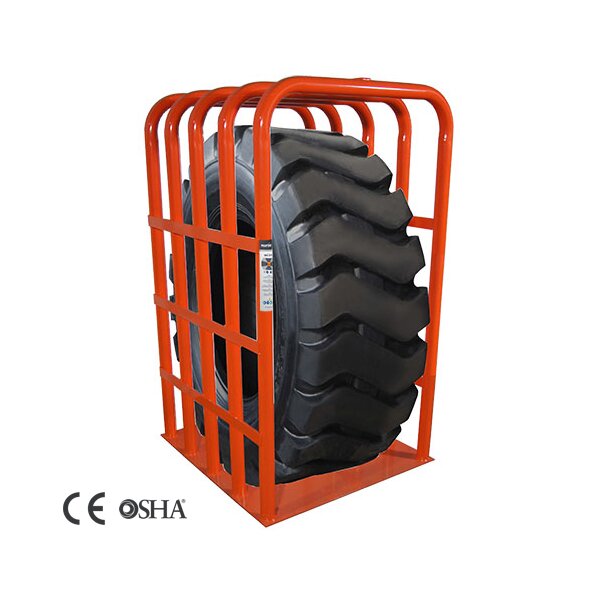 Das Bild zeigt einen großen schwarzen Reifen mit grobem Profil, der senkrecht in einem stabilen orangefarbenen Metallkäfig steht, der aus vertikalen und horizontalen Streben besteht; unten links befinden sich die Logos von CE und OSHA.