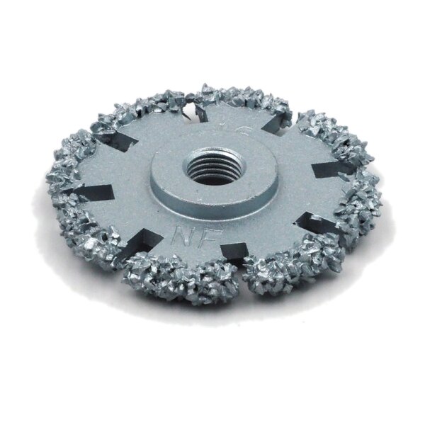 Das Bild zeigt eine grobe, runde Metallscheibe mit einer zentralen Öffnung mit Gewinde. Der äußere Rand der Scheibe ist mit dicken, rauen Schleifkörnern oder Metallspitzen bedeckt. Die Scheibe ist silbergrau und besitzt mehrere rechteckige Aussparungen, die vom Rand Richtung Mitte verlaufen.