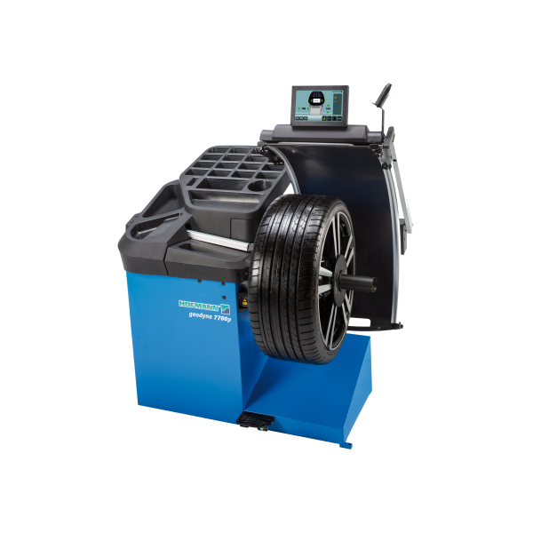 Das Bild zeigt eine blaue Auswuchtmaschine für Autoreifen mit der Aufschrift Hofmann geodyna 7700p, auf der ein Autoreifen montiert ist. Oben auf der Maschine befindet sich ein Bildschirm mit verschiedenen Bedienelementen.