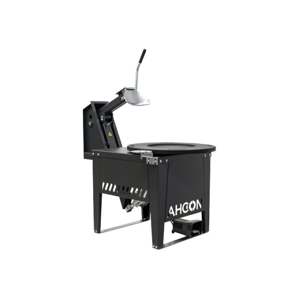Das Bild zeigt eine schwarze, rechteckige Maschine mit Beinen, einer runden Aussparung in der Oberseite und einem Hebelarm mit Handgriff, die für den Werkstattgebrauch ausgelegt ist und vorne das weiße Logo AHCON trägt.