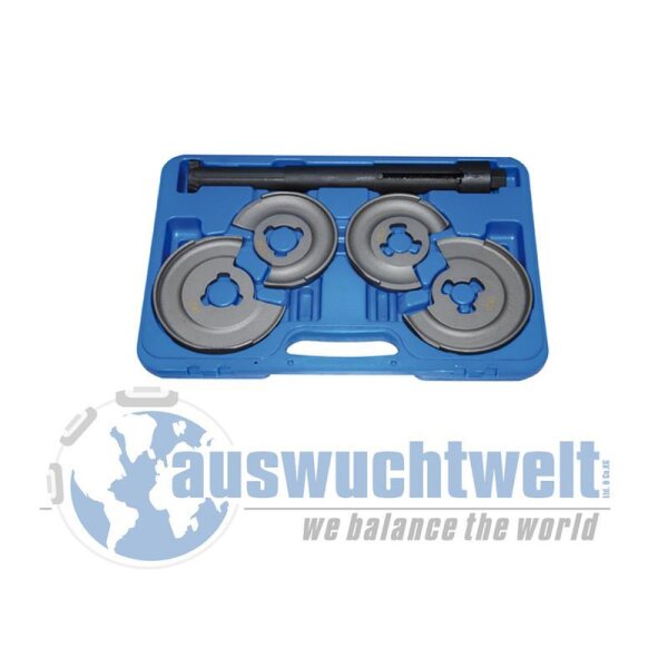 Das Bild zeigt einen blauen Kunststoffkoffer, der geöffnet ist. Darin befinden sich vier unterschiedlich große, halbrunde silberne Metallgewichte mit einem Loch in der Mitte sowie ein längliches schwarzes Metallwerkzeug. Im unteren Bereich des Bildes ist in großen blauen Buchstaben auswuchtwelt zu lesen, darunter steht in kleineren grauen Buchstaben we balance the world. Auf der linken Seite ist ein stilisiertes Globus-Symbol zu sehen.
