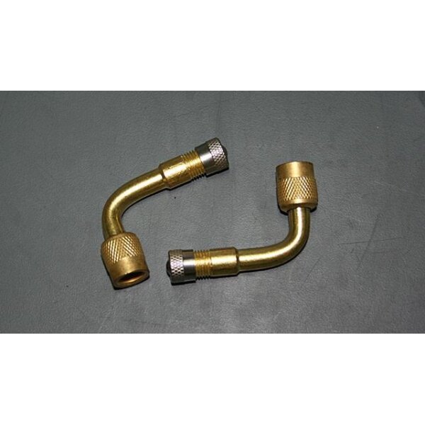 Auf dem Bild sind zwei L-förmige Metallventile abgebildet. Sie bestehen aus Messing und haben silberne Kappen mit Rillen für besseren Griff. Die Ventile liegen auf einer grauen Oberfläche. Sie scheinen identisch zu sein und weisen jeweils einen rechten Winkel auf.