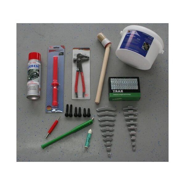 Das Bild zeigt eine Sammlung von Werkzeugen und Materialien auf einer grauen Oberfläche. Links oben ist eine rote Sprühdose. Daneben gibt es ein rotes Kunststoffwerkzeug in einer Verpackung und eine Zange mit roten Griffen. Rechts von der Zange steht ein runder Behälter mit Griff, offenbar ein Eimer. Darunter befindet sich eine kleine, grüne Schachtel mit Gewichten. Über mehrere Reihen verteilt sind unterschiedliche Metallbacken zu sehen. In der unteren linken Ecke liegt ein rotes und ein grünes Werkzeug, die wie Stifte aussehen. Darauf ist ein Reifenventilwerkzeug aufgelegt. Auch sind vier schwarze Ventile sichtbar.